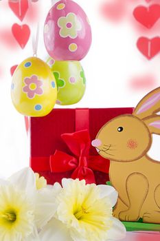 Easter decoration with rabbit, narcissus and eggs over white