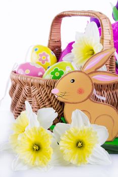 Easter decoration with rabbit, narcissus and eggs over white