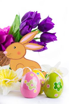 Easter decoration with rabbit, eggs and tulips over white