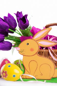 Easter decoration with rabbit, eggs and tulips over white