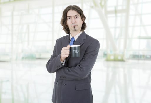 young business man with a cup of milk at the office