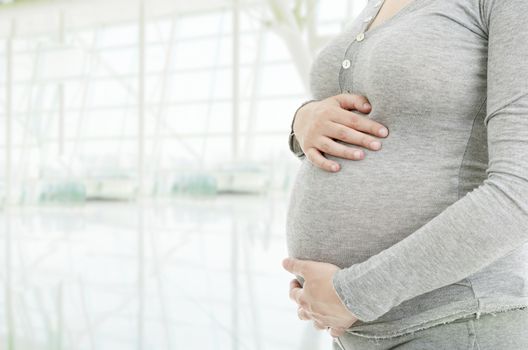 Closeup of pregnant woman at white background