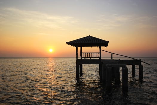  Silhouette of old pavilion in the sea at sunset