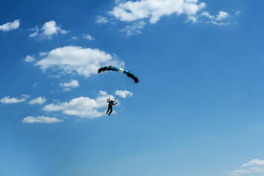 silhouette of unidentified one skydiver on blue sky