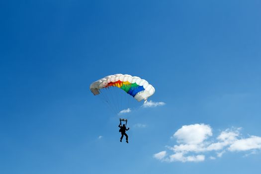 silhouette of unidentified one skydiver on blue sky
