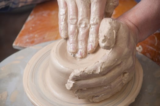 Hands of a potter, creating an earthen jar on the circle
