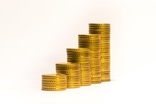 Yellow coins lined up from short to tall stacks with blank background