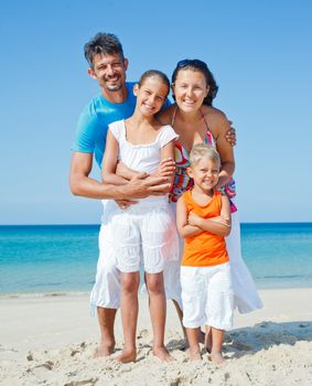 Family of four having fun on tropical beach