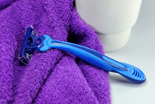 blue razor on purple towel,shallow focus