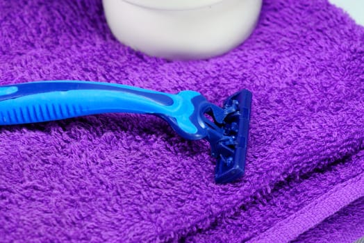 blue razor on purple towel,shallow focus