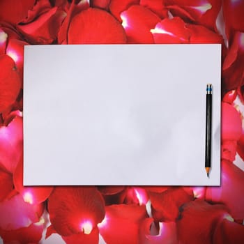 Blank white paper with pencil on red rose petals background