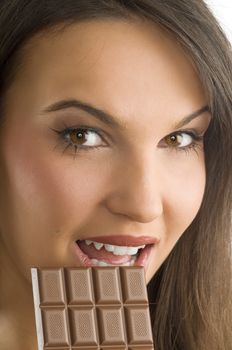 nice brunette with perfect make up eating a block of chocolate looking in camera