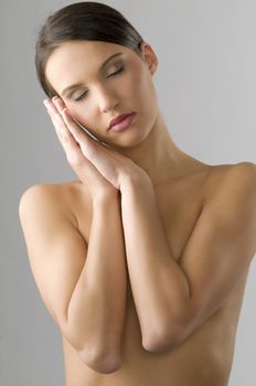 sweet portrait of a young brunette with face near hand and closed eyes