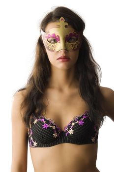 beautiful brunette wearing top lingerie and hiding face with golden mask