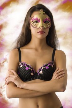 very cute brunette showing her bra lingerie with a carnival mask