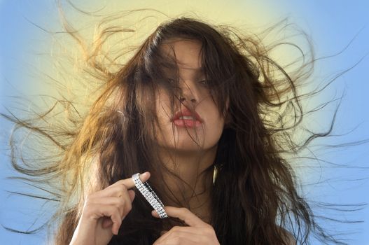 cute brunette playing with silver jewel and windly hair