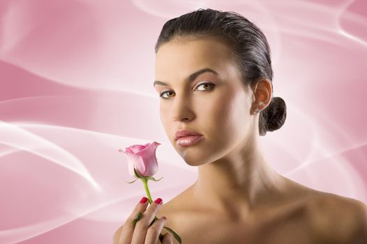 close up portrait of a pretty brunette with a pink rose looking in camera