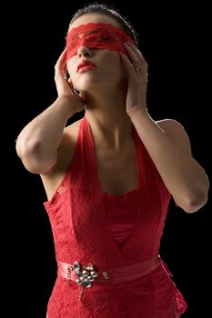 sensual portrait of a young brunette on black background with a red mask of lace