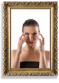 fashion portrait of beautiful woman looking at her make up inside an old frame