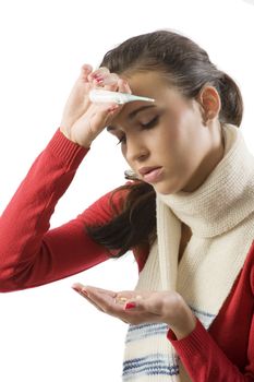 brunette wearing a white scarf and with pills and thermometer looking sick