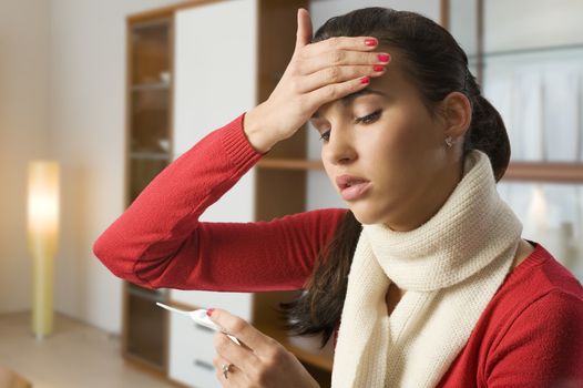 girl looking ill touching her head to check the body temperature