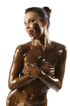 amazing shot of a young beautiful brunette with her naked body covered of sweet cream chocolate