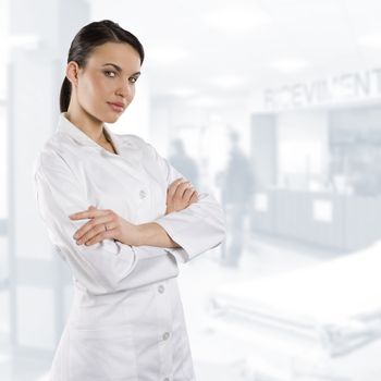 cute brunette woman in white gown as a medical doctor looking in camera