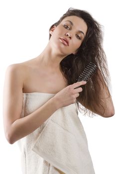 beauty shot of a young girl with a white bathrobe brushing her long wet hair