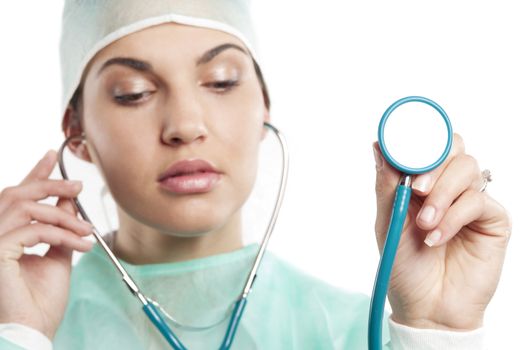 pretty nurse wearing a surgery dress with cap with a stethoscope . focus on hand