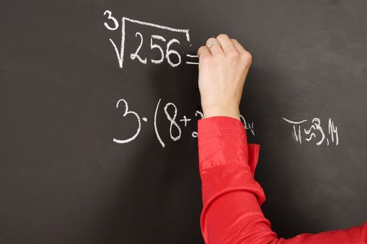 close up of a hand writing on a blackboard
