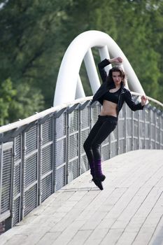 beautiful sexy woman on black trying to take a ballet pose on pointe outdoor