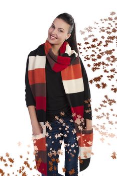 Autumn shot of a young pretty brunette wearing a dark sweater and a fall color long scarf on leaf background