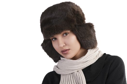beauty close up portrait of cute female woman with fashion fur hat in winter dress with scarf looking at the camera against white background