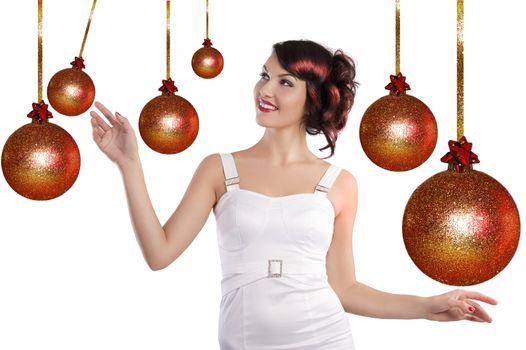 Pretty brunette with hair style and a white dress between christmas ball playing joyfully and smiling