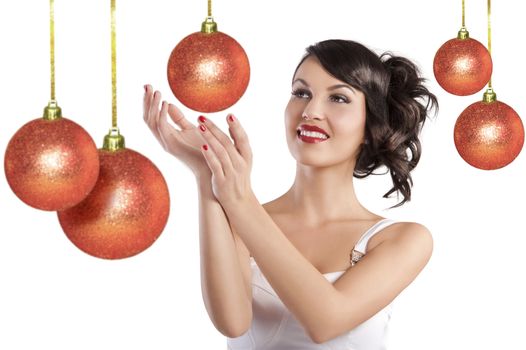 Pretty brunette with hair style and a white dress smiling and posing between christmas ball