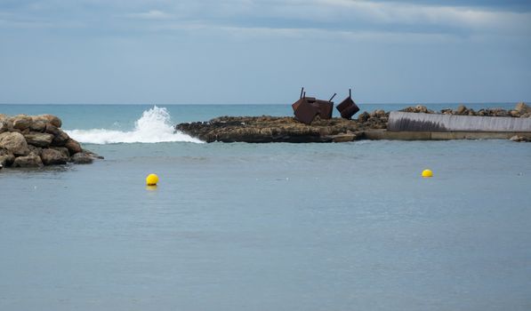 Two yellow buoys white wave and horizon, Cala Estancia, Can Pastilla, Balearic islands, Spain.
