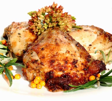 It is fried chicken thighs with sea-buckthorn on a white plate 