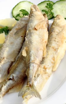 Freshly fried smelt served with cucumber and lemon