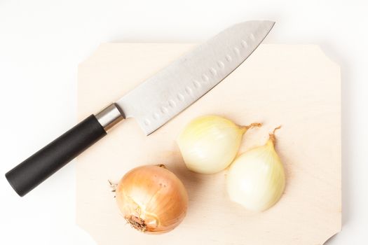 sliced onions on wooden cutting board with knife