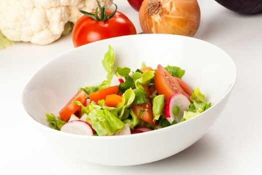 vegetable salad in a white bowl with different vegetables