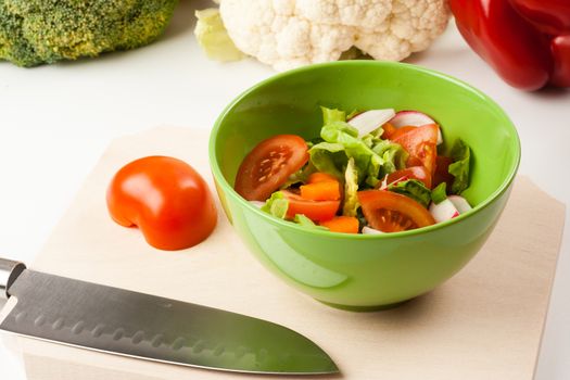 vegetable salad in a green bowl with different vegetables