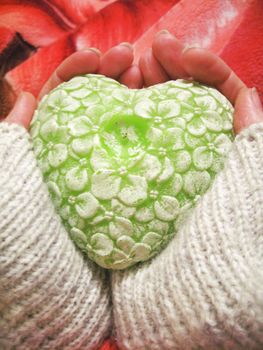 Valentine heart and heart shape candle in woman hands