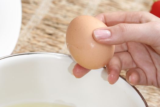 Close-up picture of hands broking eggs.