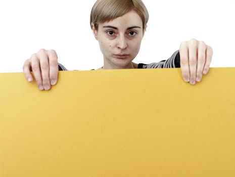 Young blonde woman holding a blank piece of paper.