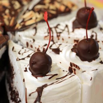 delicious cake with chocolate and cherry on top