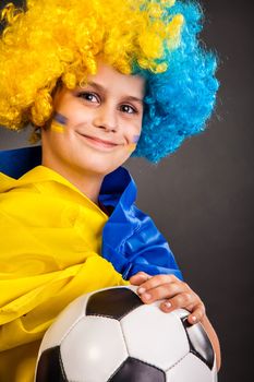 Football fan with a blue and yellow ukrainian flag painted on his face on black background