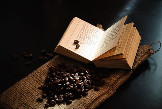 Image of roasted coffee beans and opened book.