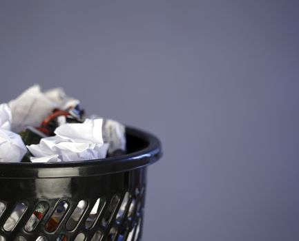 Close up photo of a trash can full of papers