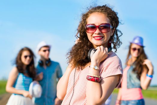 young woman with headphones on a background of blue sky and funny friends