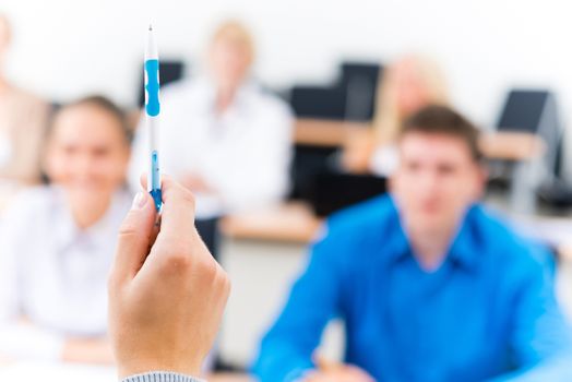 close-up of hands of a teacher with a ballpoint pen, the teacher focuses attention on himself gesture